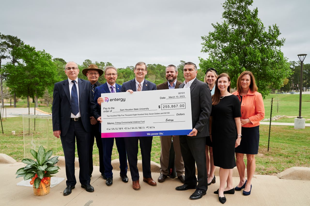 Entergy Texas representatives present a $255,000 grant to Sam Houston State University to help fund the campus' first EV fast charging station.